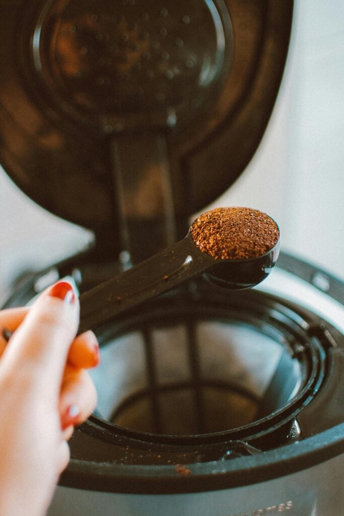 A close-up of ground coffee being measured into a coffee maker, ready to brew a fresh cup.